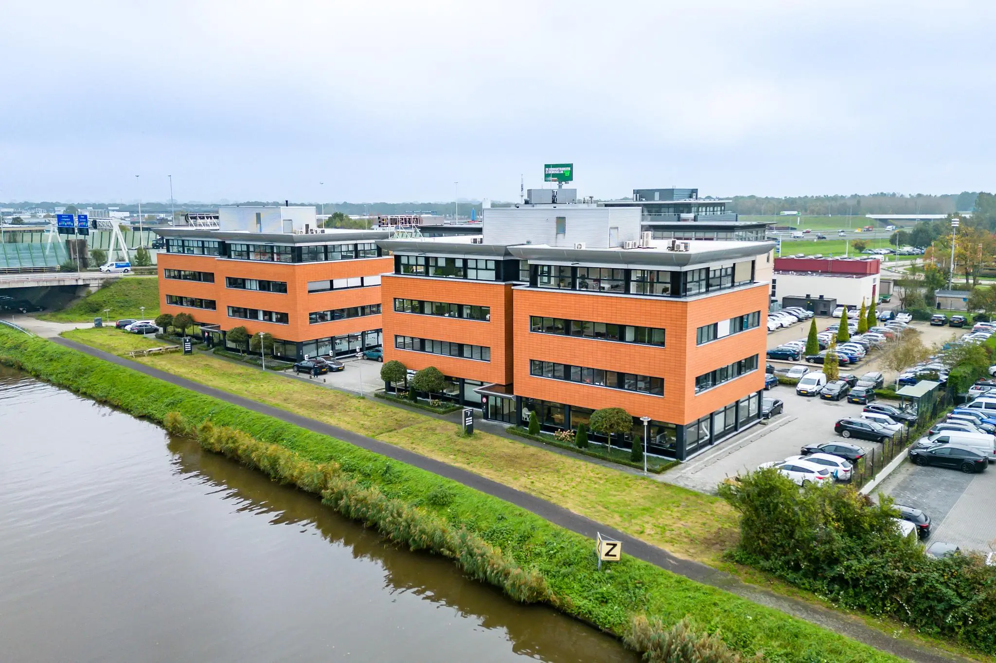 Kantoorpanden aan de Lage Biezenweg in een zakelijke omgeving met parkeergelegenheid en watergang op de voorgrond.
